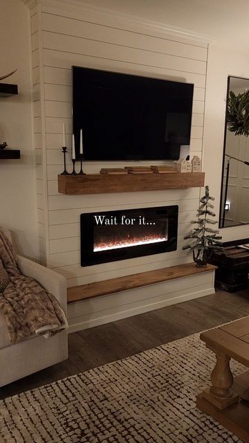 a living room with a couch, fireplace and television mounted on the wall above it