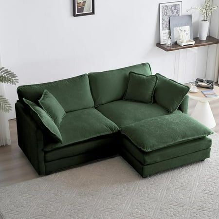 a large green couch sitting on top of a white rug