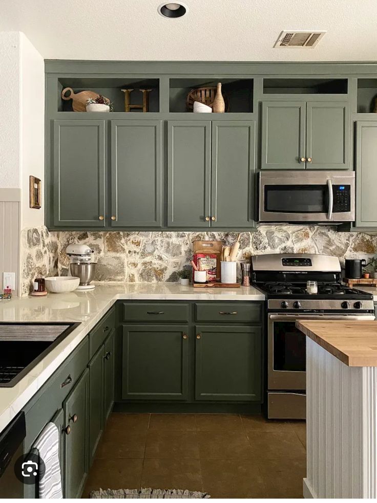 a kitchen with green cabinets and white counter tops is pictured in this image from the front view