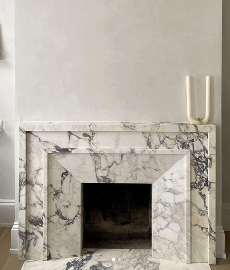 a marble fireplace with two candles on the mantle