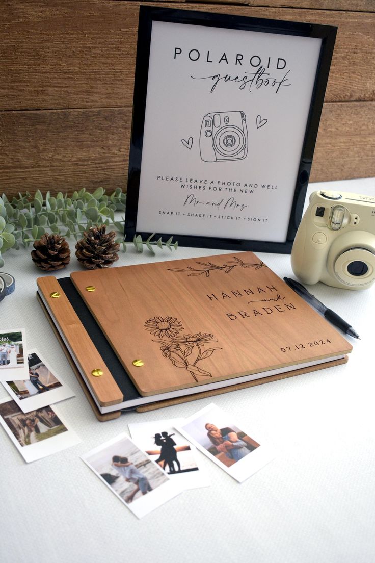 a polaroid photo album sitting on top of a table next to a camera and pine cones