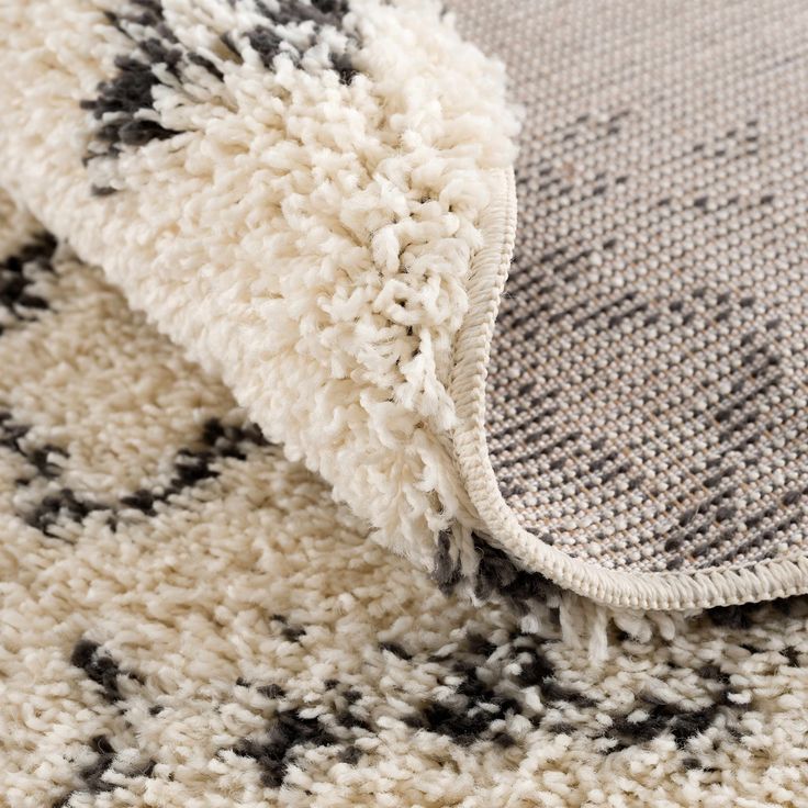 a close up view of a rug with black and white designs on the carpeting