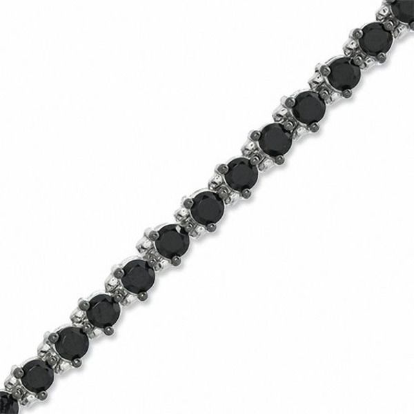 This new take on the traditional tennis bracelet is a great look for the modern sophisticate. Fashioned in sleek sterling silver, an array of glistening black spinel in three-prong settings is linked in perfect alignment, creating this bold and dramatic look. Buffed to a brilliant shine, this 7.5-inch bracelet secures with a lobster claw clasp. Elegant Bracelet With Black Diamonds, Elegant Black Diamond Round Bracelets, Formal Black Spinel Jewelry With Diamond Accents, Elegant Black Diamond Round Bracelet, Classic Tennis Bracelet With Black Diamonds, Formal Tennis Bracelet With Black Diamonds, Classic Round Black Diamond Bracelet, Classic Tennis Bracelet With Black Diamonds For Formal Occasions, Classic Black Diamond Bracelet For Formal Occasions