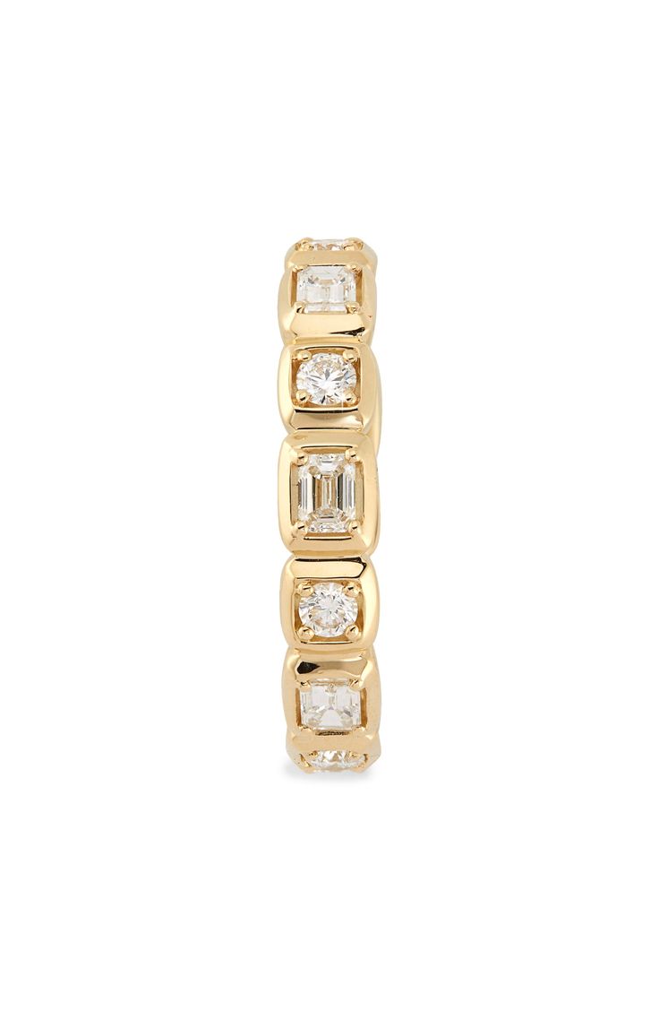 a yellow gold ring with three baguettes and diamonds on the sides, set against a white background