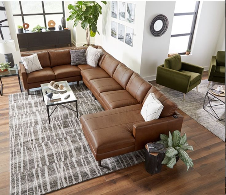 a living room filled with lots of furniture and decor on top of a hard wood floor