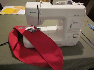 a sewing machine with a red ribbon on it's side sitting on top of a table