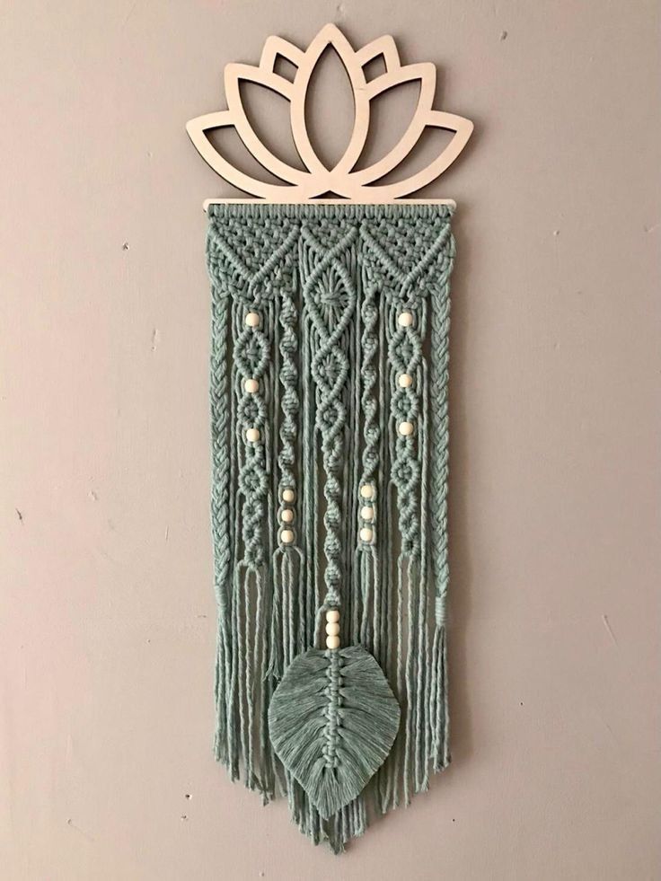 a green wall hanging with a flower on it