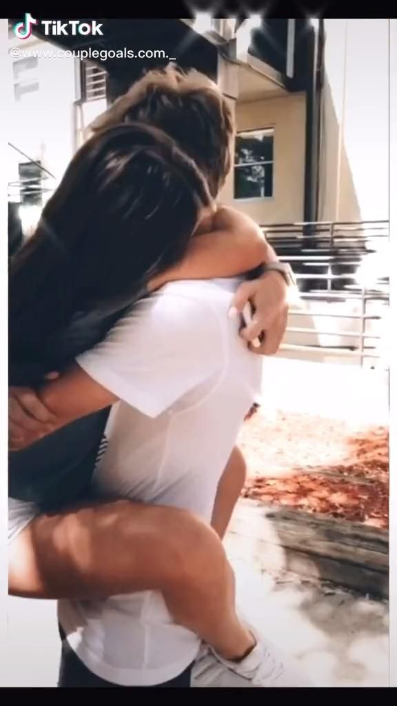 two people hugging each other on the street