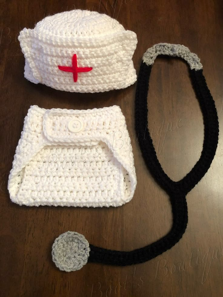 a crocheted hat, diaper cover and stethoscope on a table