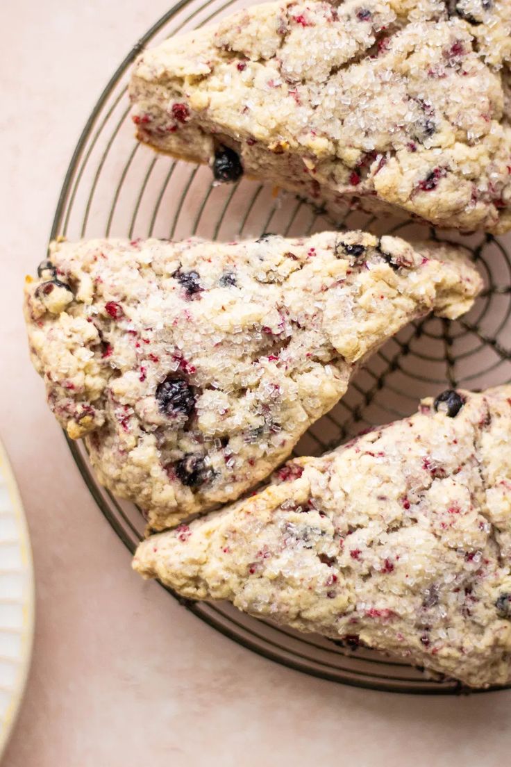 blueberry scones on a wire rack next to a plate with one piece cut out