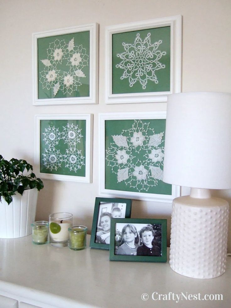 three framed pictures are on the wall above a table with drinks and a potted plant