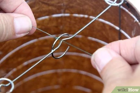 someone is holding the end of a wire with two fingers and pulling it up on a circular