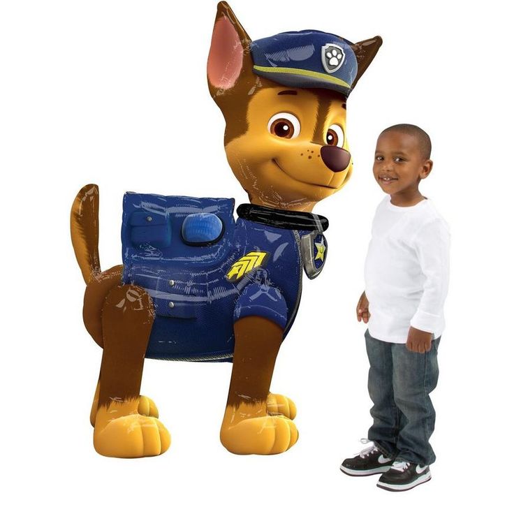 a little boy standing next to a large inflatable toy dog that looks like a police officer