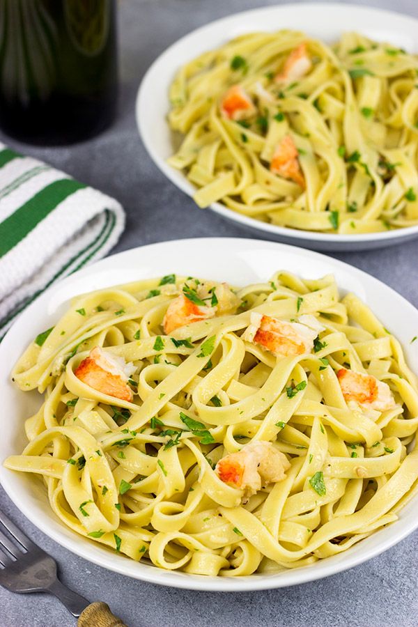 two plates of pasta with shrimp and parsley