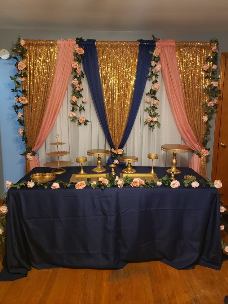 the table is set up with two candles and flowers on it, along with gold candelabras