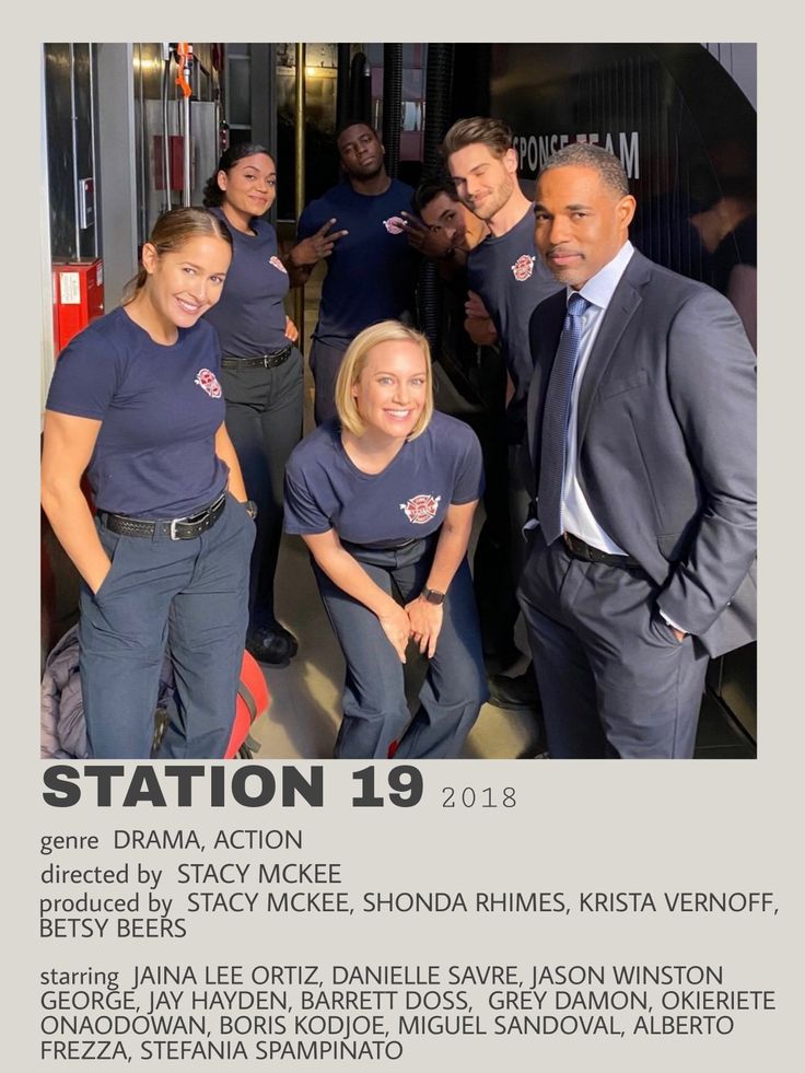 a group of people standing next to each other in front of a fire station sign