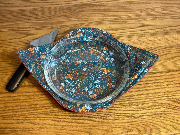 a wooden table with a glass plate on top of it and a knife next to it