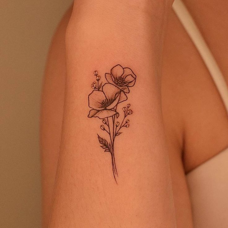 a woman's arm with a flower tattoo on the left side of her arm