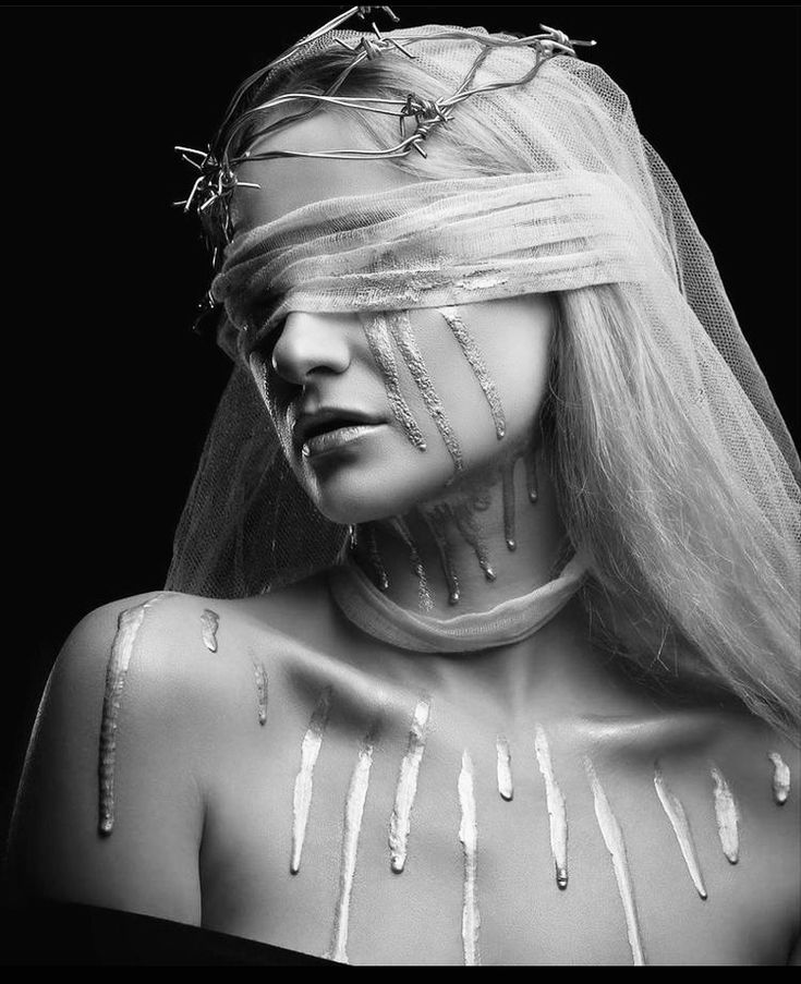 a black and white photo of a woman's face covered in silver threads