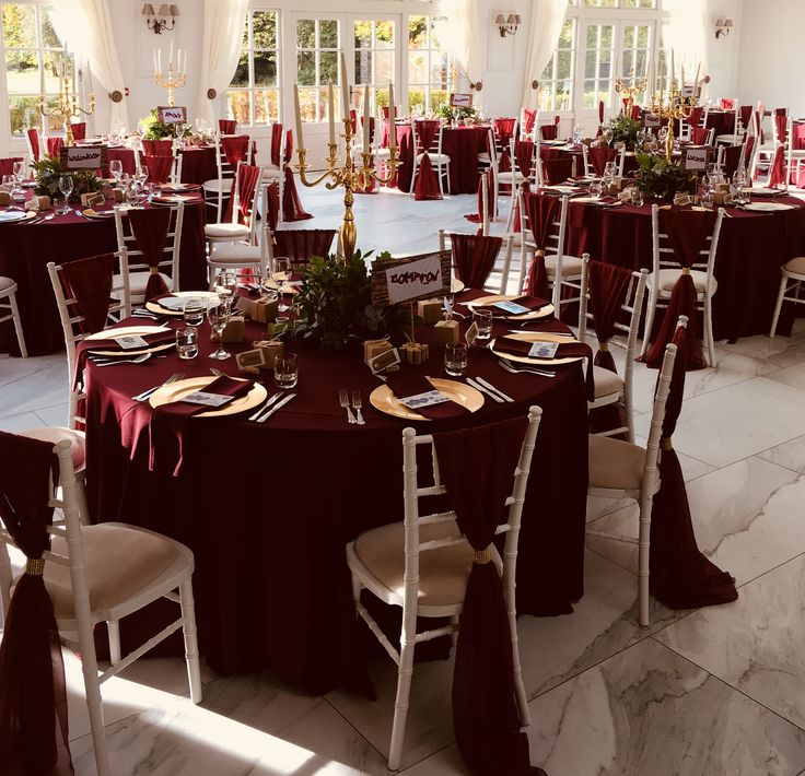 the tables are set up with red and white linens for an elegant wedding reception