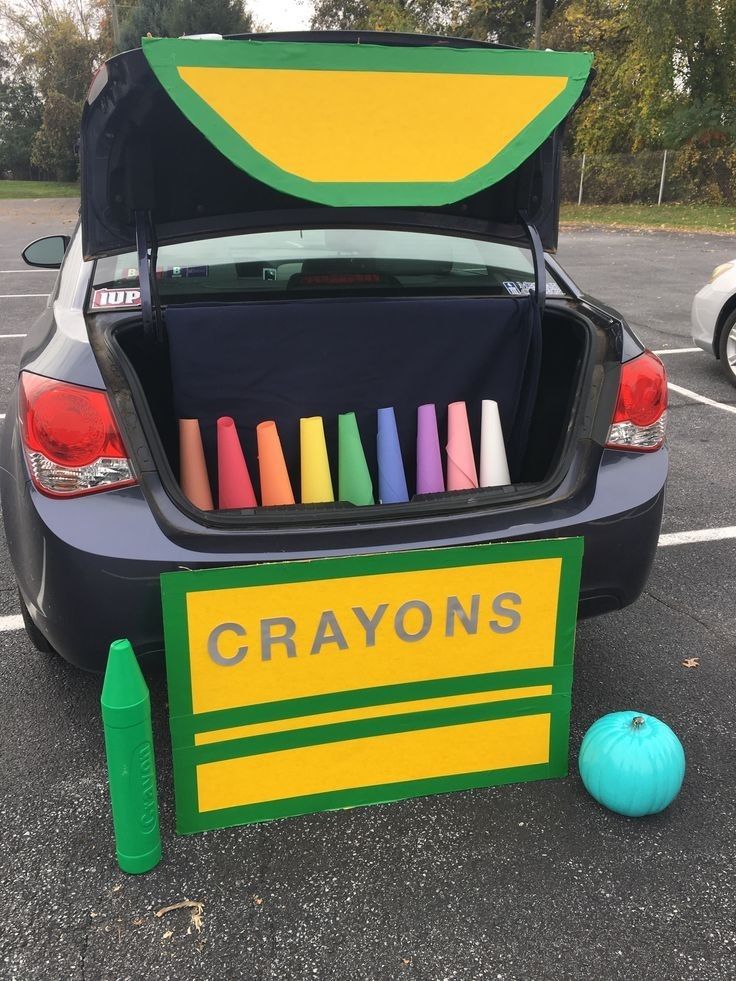 a car trunk filled with crayons sitting in a parking lot next to a blue ball