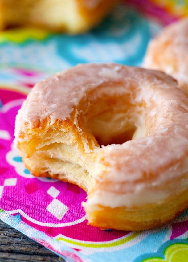 two glazed donuts sitting on top of a colorful napkin