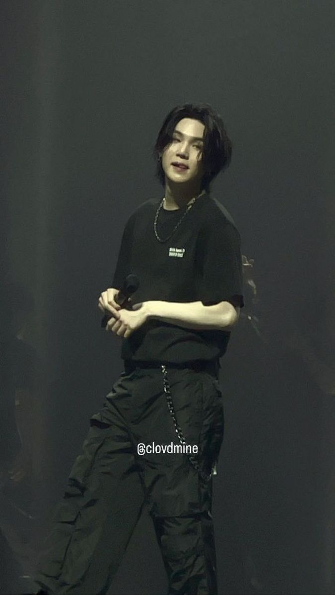 young man in black shirt and pants standing on stage