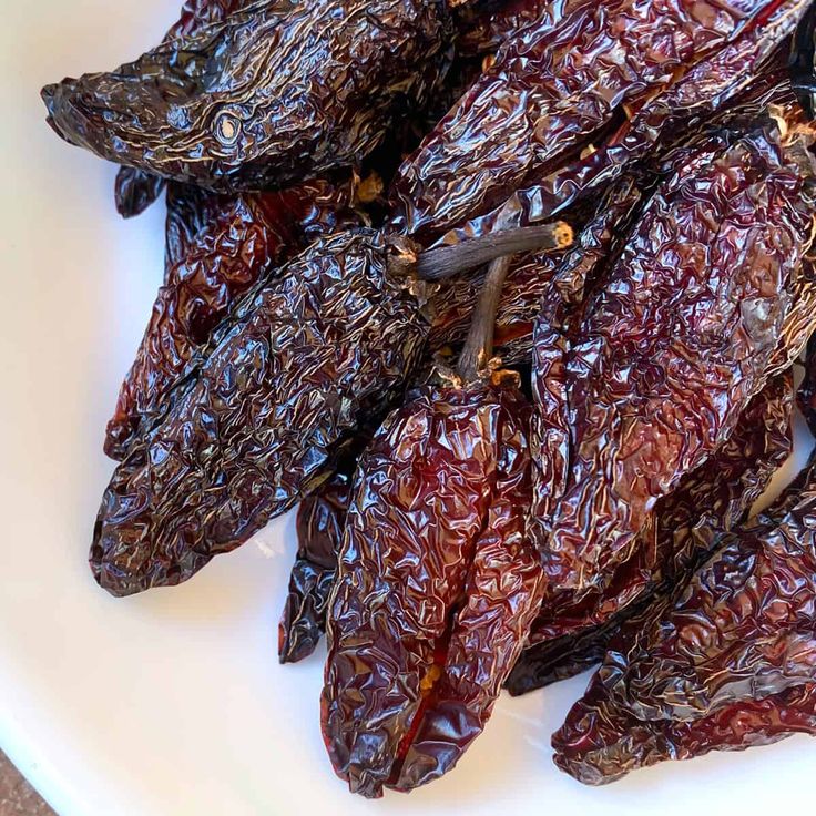 some dried red peppers on a white plate