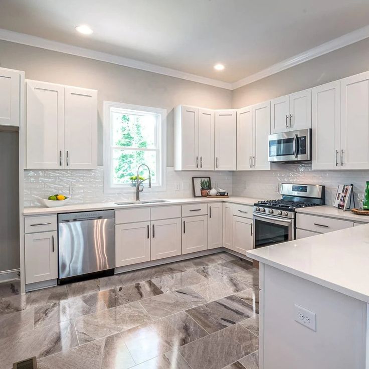 a kitchen with marble floors and white cabinets