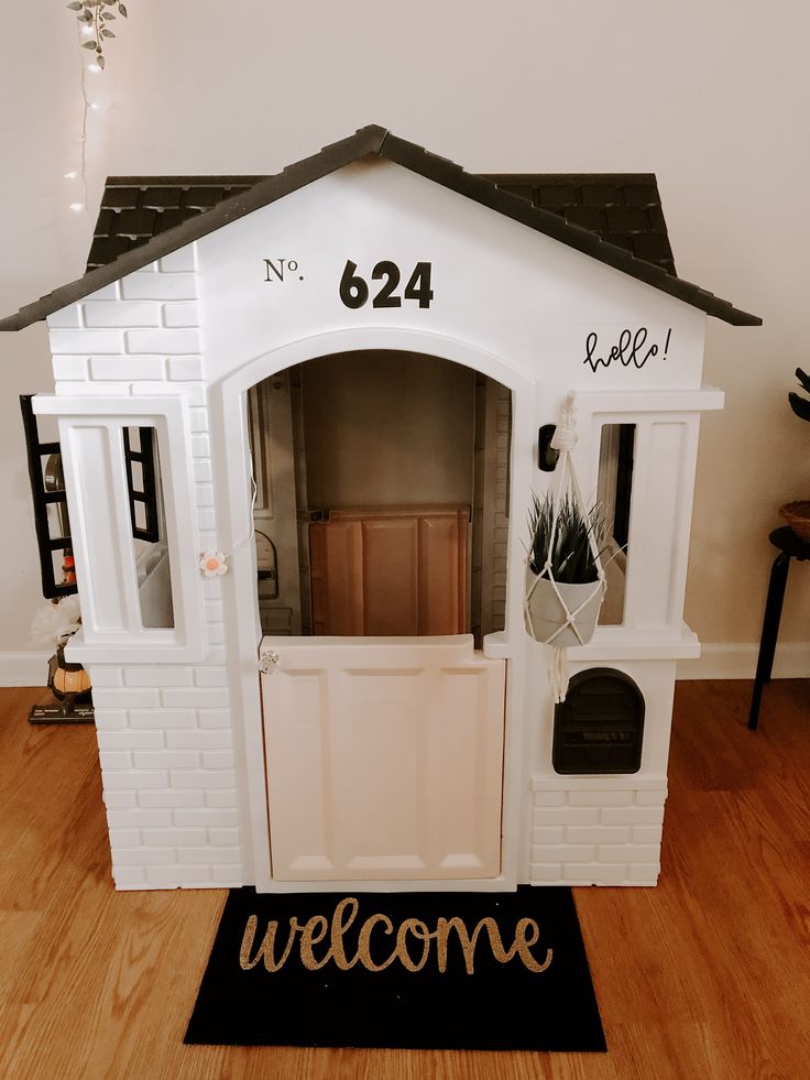 a white dog house with the door open and welcome mat in front of it that says, no 644