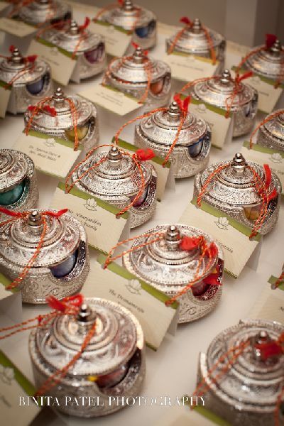 many small silver dishes with tags tied around them