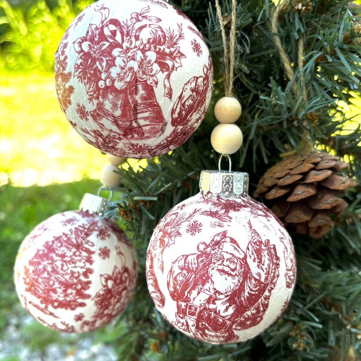 three red and white ornaments hanging from a tree