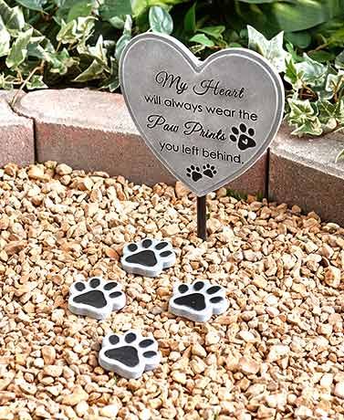 two paw prints are placed in front of a heart shaped plaque with the words, my heart will always wear the paw prints you left behind