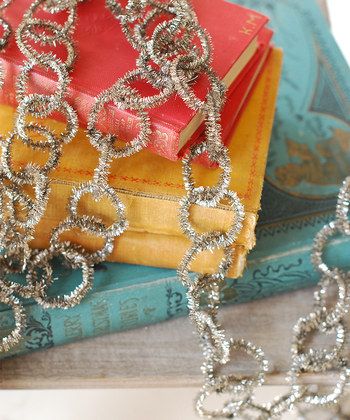 the silver thread link garland is sitting on top of books