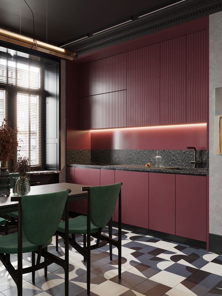 a kitchen with checkered flooring and pink cabinets, black counter tops and green chairs