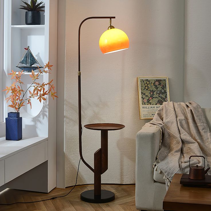 a living room with a couch, table lamp and bookshelf in the corner