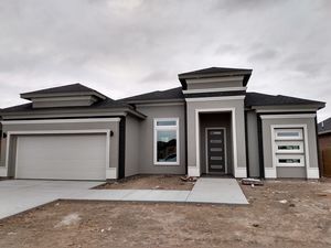 a gray house sitting on top of a dirt field