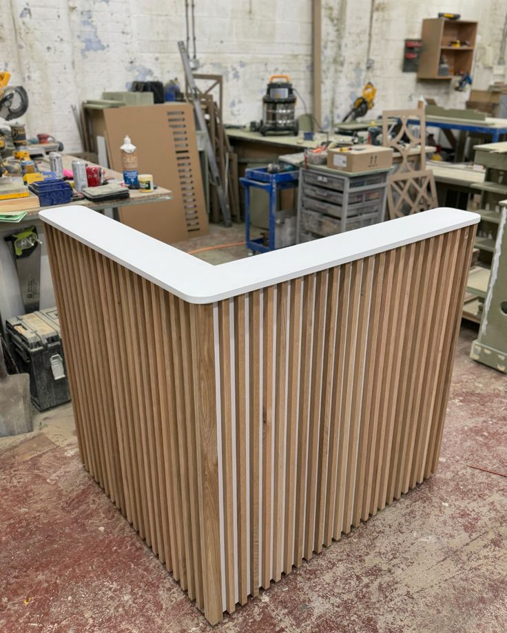 an unfinished counter in a shop with lots of work on the table and tools behind it