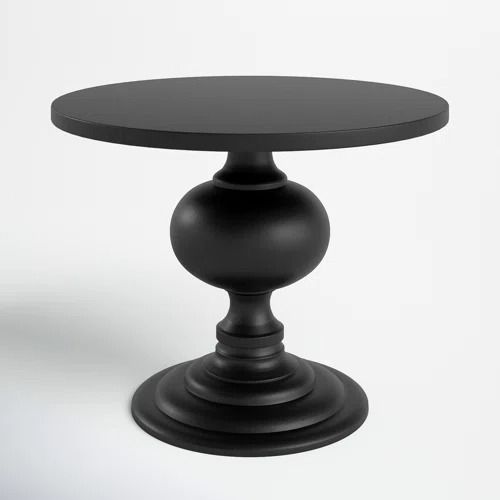 a black round table sitting on top of a white floor