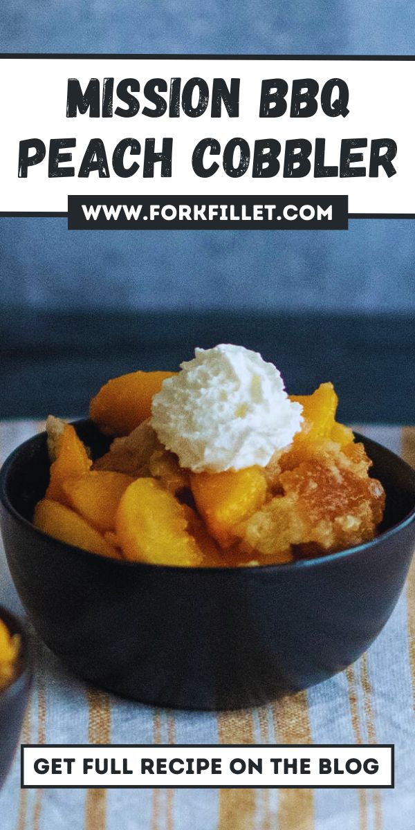 a black bowl filled with peach cobbler and whipped cream