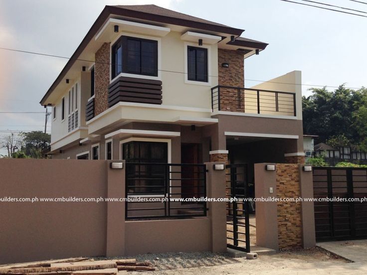 a two story house with a brown fence around it