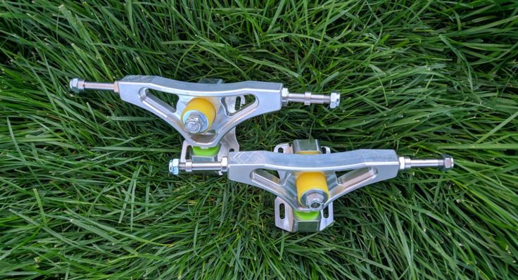 two skateboard wheels laying on top of green grass in the middle of it's blades