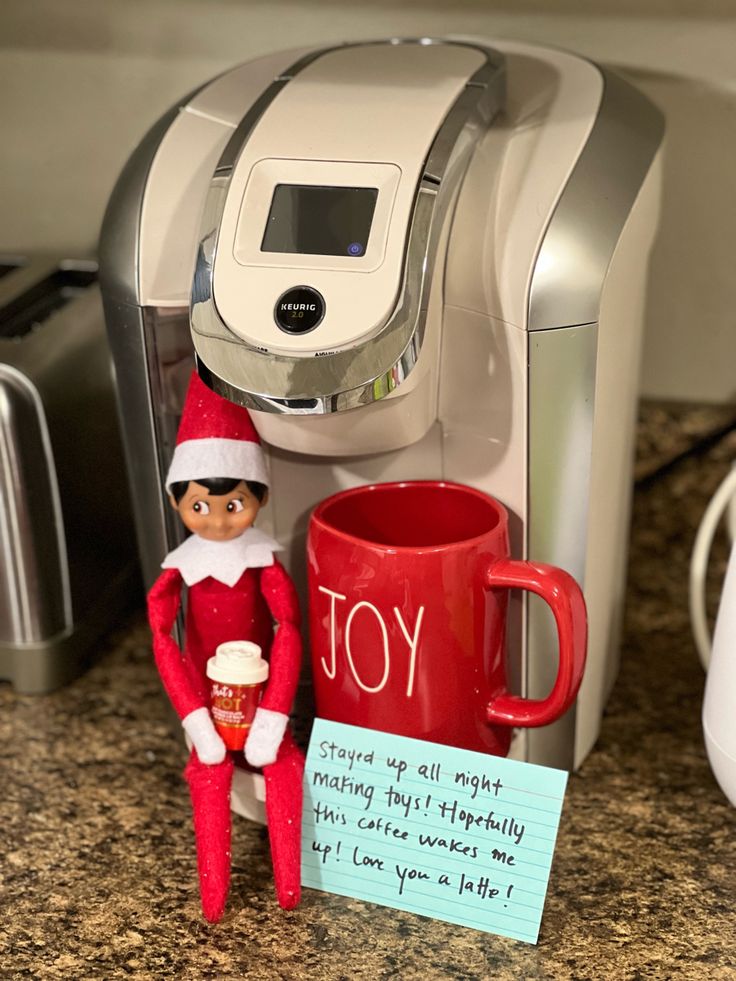 an elf is sitting next to a coffee maker