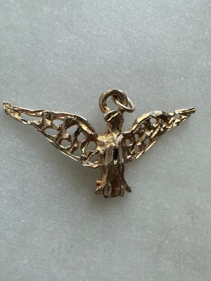 14K Vintage Solid Gold Bird Pendant Description: This 14K Vintage Solid Gold Bird Pendant, depicting an American Eagle or Hawk, is a striking addition to any jewelry collection. Its unique design captures the majestic essence of these powerful birds. Perfect for any occasion, this pendant adds a bold and stylish touch to your ensemble. This piece, like all our jewelry, is a rare find--once it's gone, it's gone. Choosing this piece is a win-win: You'll stand out from the crowd and help the enviro Bird Pendant, Charm Necklace, Unique Pieces, Solid Gold, Unique Design, American Eagle, Jewelry Collection, Vintage Jewelry, Jewelry Accessories