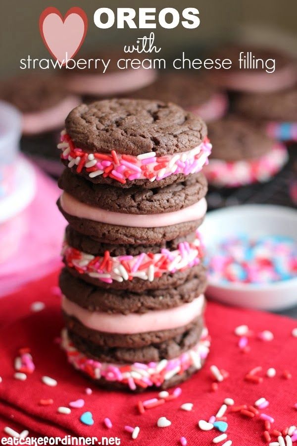 a stack of cookies with frosting and sprinkles on a red cloth