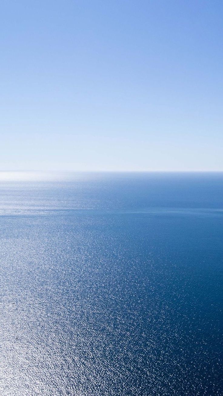 an airplane flying over the ocean on a clear day