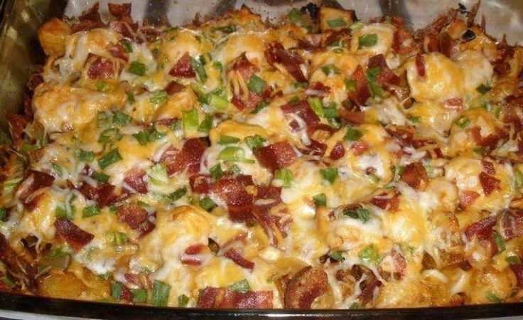 a casserole dish with bacon, cheese and green onions