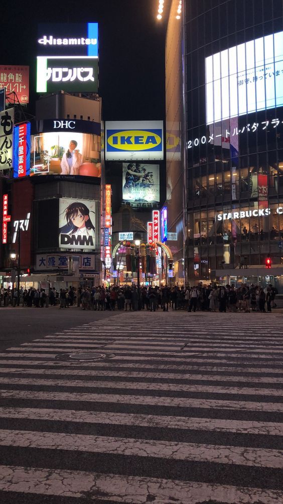 a crosswalk in the middle of a city at night