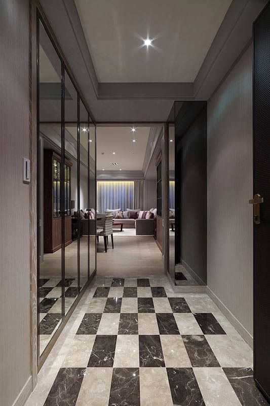 an elegant hallway with black and white checkered flooring is seen in this image