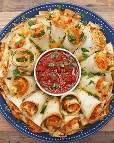 a blue plate topped with tortillas covered in sauce